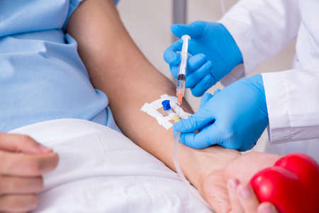 Male patient getting blood transfusion in hospital clinicの写真素材