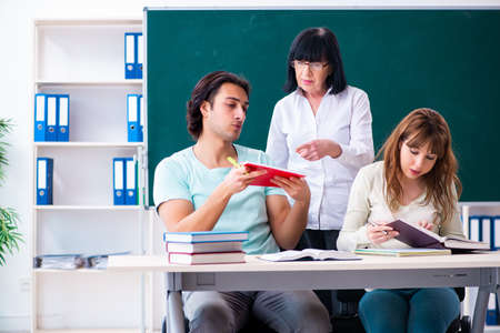 Old teacher and students in the classroomの写真素材