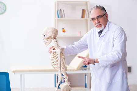 Aged male doctor with skeletonの写真素材