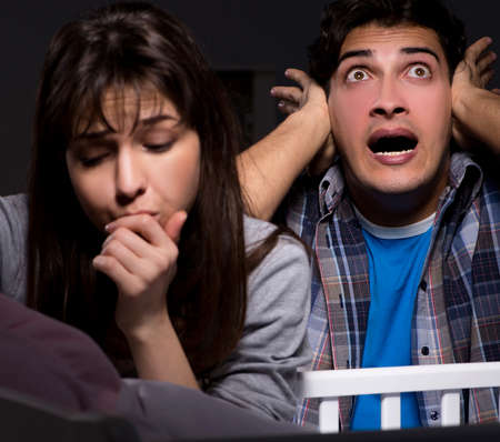 Young parents sleepless with newborn baby at nightの写真素材