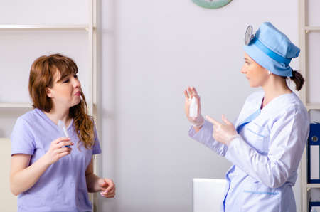 Young woman visiting female doctor otolaryngologistの写真素材