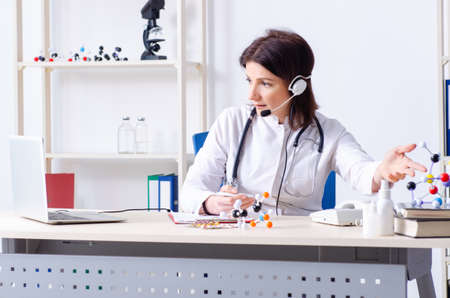 Middle-aged female doctor in telemedicine conceptの写真素材