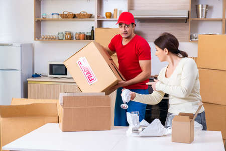 Young male contractor and female customer in moving concept