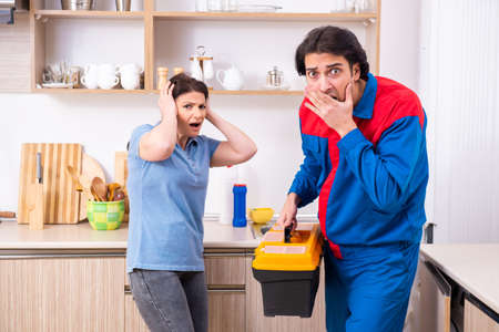 Young male repairman repairing tapの写真素材