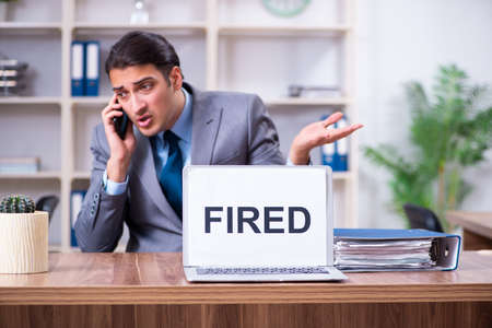 Young male employee being fired from his workの写真素材