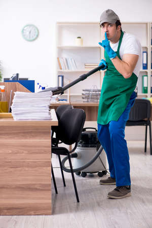 Young handsome contractor cleaning the office