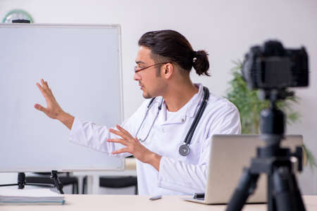 Young male doctor recording video for his blog