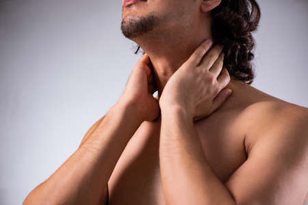 Young man suffering from neck painの写真素材