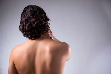 Young man suffering from neck painの写真素材