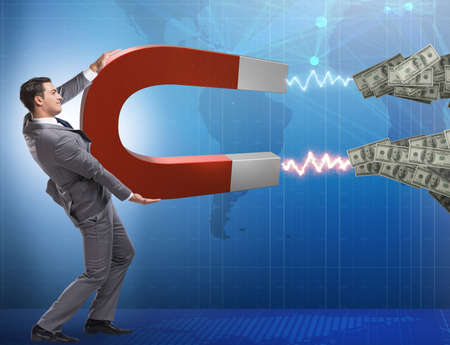 Businessman catching dollars on horseshoe magnetの写真素材