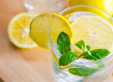 The glasss of mojito with lemon and drinking straw