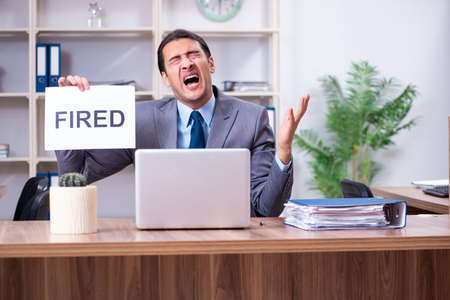 Young male employee being fired from his workの写真素材