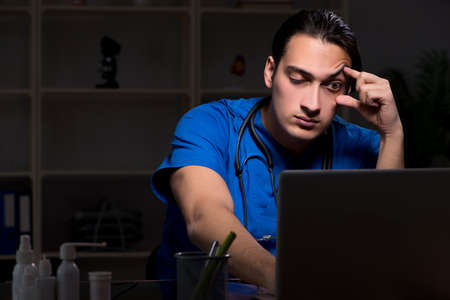 Young male doctor in the hospital at nightの写真素材
