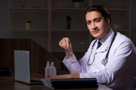 Young male doctor in the hospital at nightの写真素材