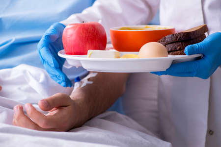 The male patient eating food in the hospitalの写真素材
