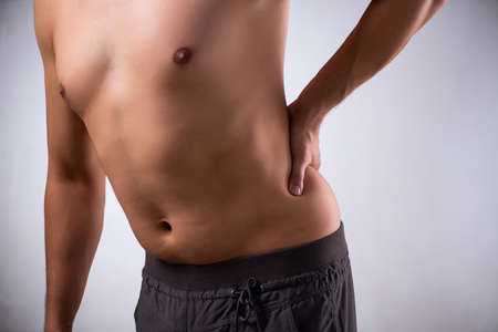 The man suffering from backbain on grayの写真素材