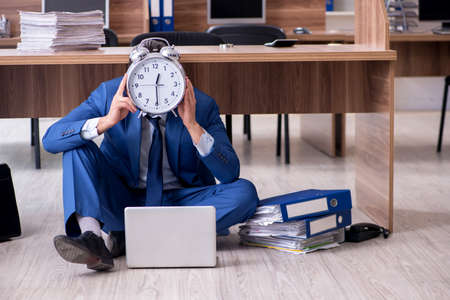 The young male employee and too many work in the officeの写真素材