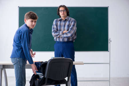 Funny male teacher and boy in the classroomの写真素材