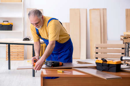 Old male carpenter working in workshopの写真素材