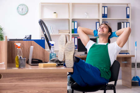 Young handsome contractor cleaning the officeの写真素材