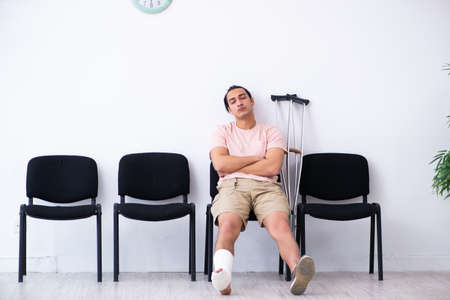 Young injured man waiting for his turn in hospital hall