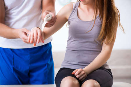 Fitness instructor helping woman during exercise