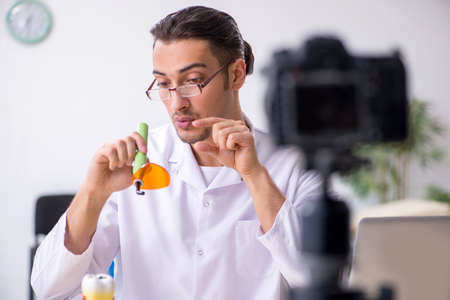 Young male doctor dentist recording video for his blogの写真素材