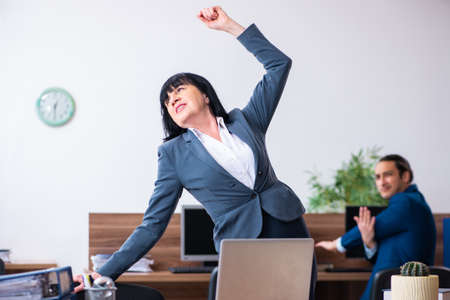 Two employees doing sport exercises in the officeの写真素材