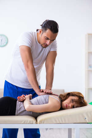 Young woman visiting male doctor physiotherapistの写真素材