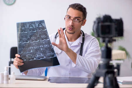 Young male doctor radiologist recording video for his blog