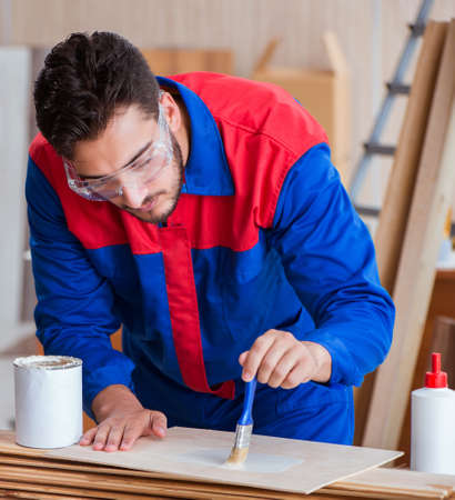 Yooung repairman carpenter working with paint paintingの写真素材