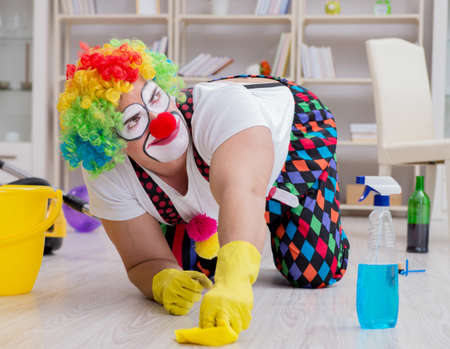 Funny clown doing cleaning at homeの写真素材