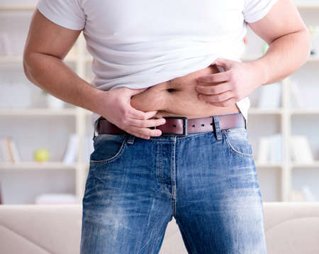 Man suffering from extra weight in diet conceptの写真素材