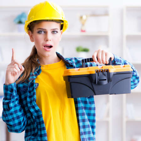 Woman with toolkit in workshopの写真素材