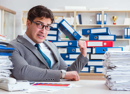 Businessman busy with much paperworkの写真素材