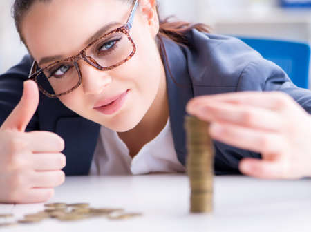 Businesswoman with coins in forex conceptの写真素材