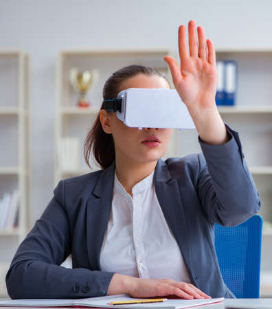 Businesswoman with virtual reality glasses in officeの写真素材
