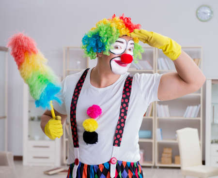 Funny clown doing cleaning at homeの写真素材