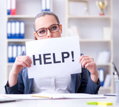 Businesswoman pleading for help in officeの写真素材