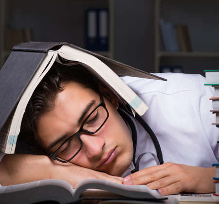 Medical student preparing for university exams at nightの写真素材