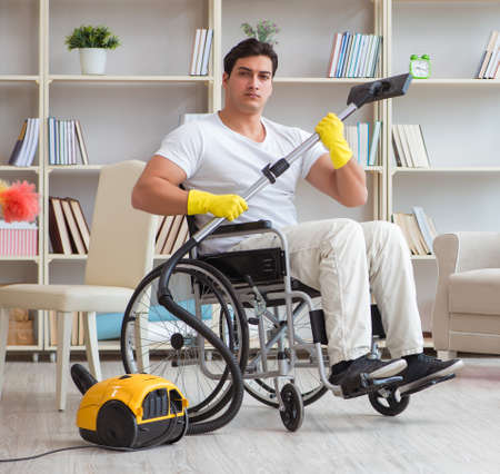 Disabled man with vacuum cleaner at homeの写真素材