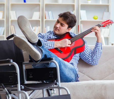 Disabled man playing guitar at homeの写真素材