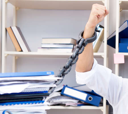 Employee attached and chained to his desk with chain