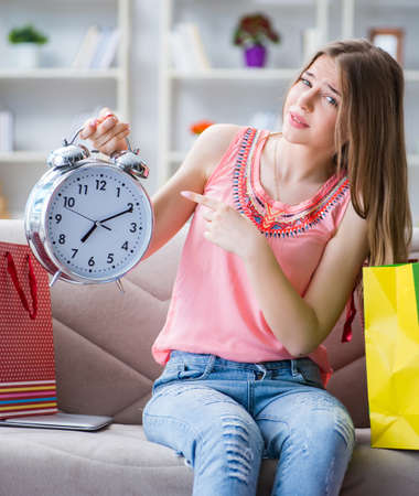 Young woman with shopping bags indoors home on sofaの写真素材