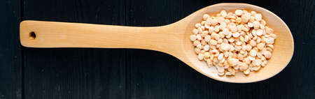 Spoons filled with uncooked lentil for soupの写真素材