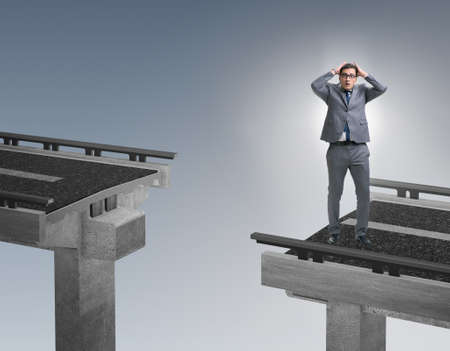 Young businessman in uncertainty concept with bridgeの写真素材