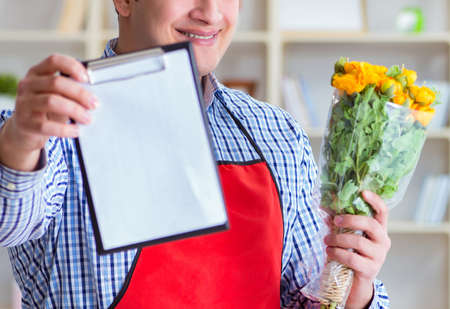 Flower shop assistant offering a bunch of flowersの写真素材