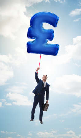 Businessman flying on british pound sign inflatable balloonの写真素材