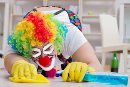 Funny clown doing cleaning at homeの写真素材
