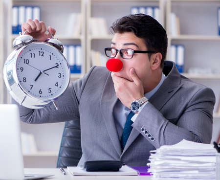 Clown businessman with alarm clock missing deadlineの写真素材